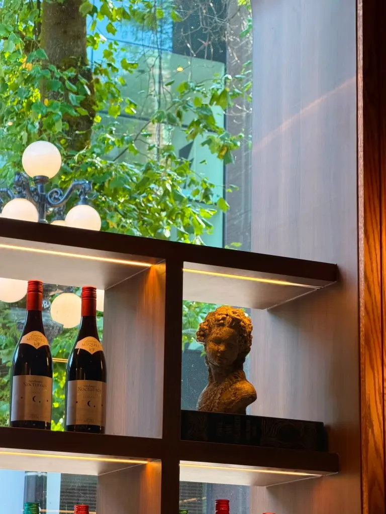 Entrecôte wine shelf with greenery visible through the window